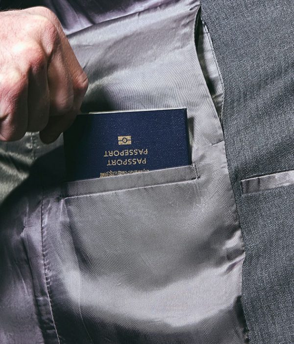 Passport being inserted into an inside jacket pocket