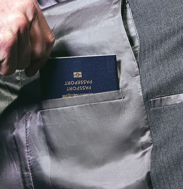 Passport being inserted into an inside jacket pocket