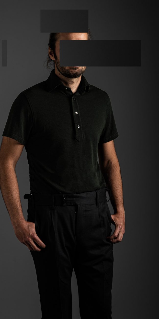 redacted man in studio wearing green merino pique polo shirt by Grayman and Company with grey backdrop