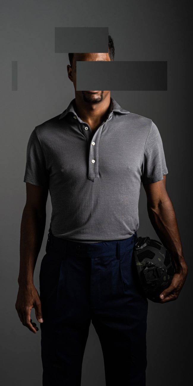 redacted man in studio wearing light grey merino pique polo shirt by Grayman and Company with grey backdrop