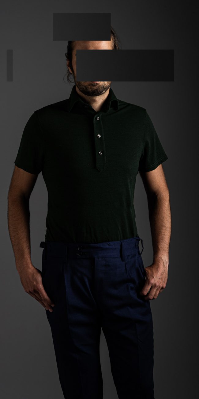 redacted man in studio wearing dark green merino pique polo shirt by Grayman and Company with grey backdrop