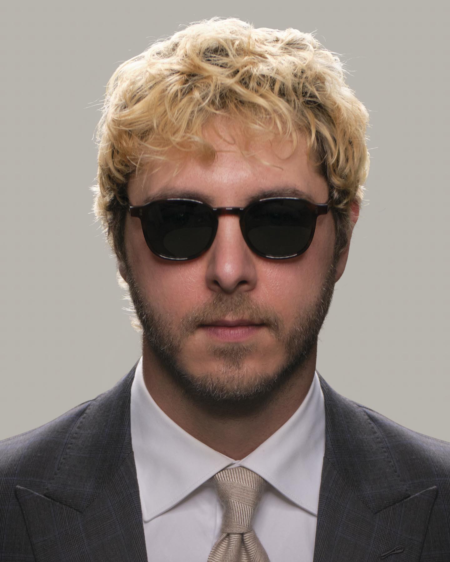 Headshot of man in tactical suit and Grayman and Company KH12 wayfarer ballistic impact resistant sunglasses